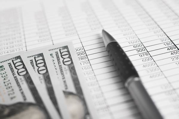 Доступні франшизи до $10 тис. для підприємців 10 Гроші, бухгалтерські документи, рахунки та ручка. Крупний план, вид знизу, вибірковий фокус